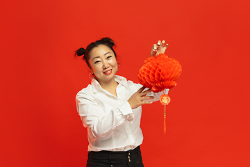 Image showing Happy Chinese New Year. Asian young woman portrait isolated on red background