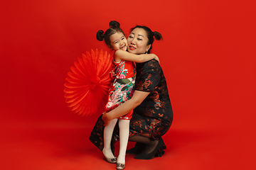 Image showing Happy Chinese New Year. Asian mother and daughter portrait isolated on red background