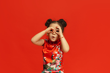 Image showing Happy Chinese New Year. Asian little girl portrait isolated on red background