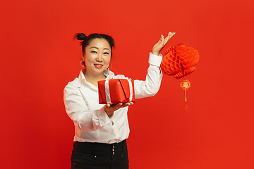 Image showing Happy Chinese New Year. Asian young woman portrait isolated on red background