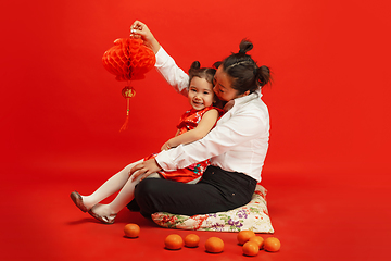 Image showing Happy Chinese New Year. Asian mother and daughter portrait isolated on red background