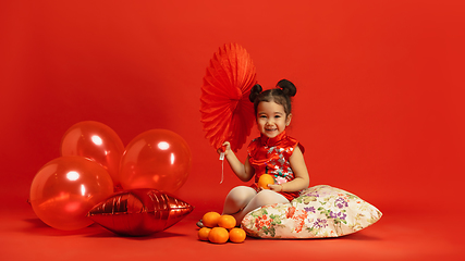 Image showing Happy Chinese New Year. Asian little girl portrait isolated on red background