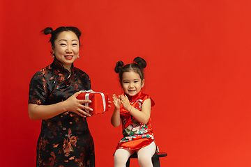 Image showing Happy Chinese New Year. Asian mother and daughter portrait isolated on red background