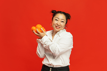 Image showing Happy Chinese New Year. Asian young woman portrait isolated on red background