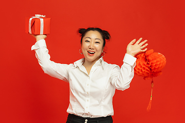 Image showing Happy Chinese New Year. Asian young woman portrait isolated on red background