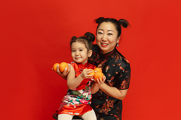 Image showing Happy Chinese New Year. Asian mother and daughter portrait isolated on red background