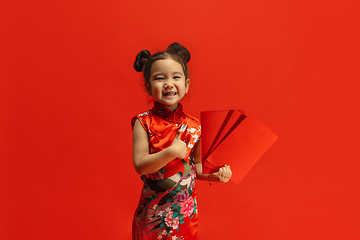 Image showing Happy Chinese New Year. Asian little girl portrait isolated on red background