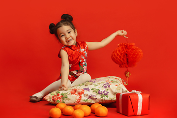 Image showing Happy Chinese New Year. Asian little girl portrait isolated on red background