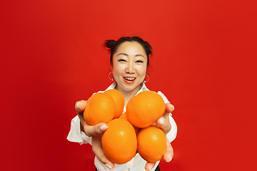 Image showing Happy Chinese New Year. Asian young woman portrait isolated on red background