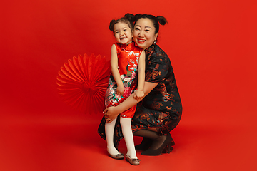 Image showing Happy Chinese New Year. Asian mother and daughter portrait isolated on red background