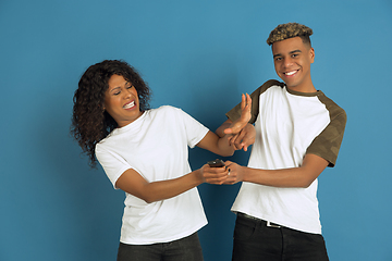 Image showing Young emotional african-american man and woman on blue background