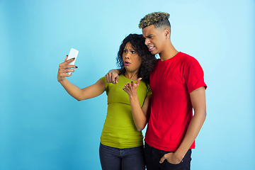 Image showing Young emotional african-american man and woman on blue background