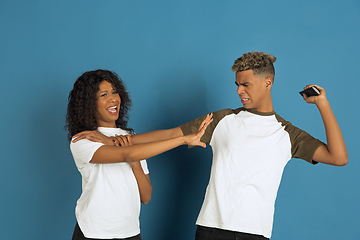 Image showing Young emotional african-american man and woman on blue background