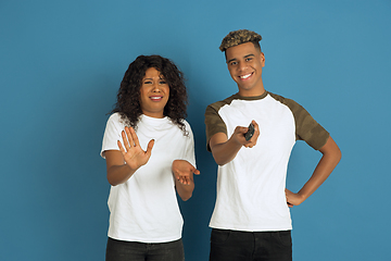 Image showing Young emotional african-american man and woman on blue background