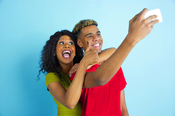 Image showing Young emotional african-american man and woman on blue background