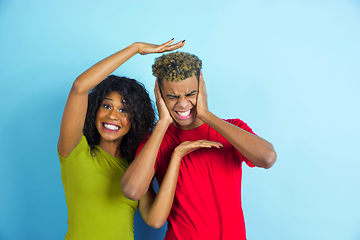 Image showing Young emotional african-american man and woman on blue background