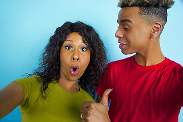 Image showing Young emotional african-american man and woman on blue background