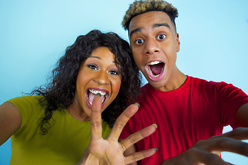 Image showing Young emotional african-american man and woman on blue background