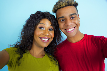 Image showing Young emotional african-american man and woman on blue background