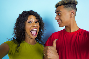 Image showing Young emotional african-american man and woman on blue background