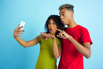 Image showing Young emotional african-american man and woman on blue background