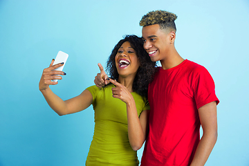 Image showing Young emotional african-american man and woman on blue background