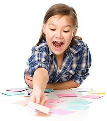 Image showing Girl is writing on color stickers using pen