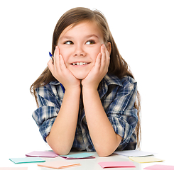 Image showing Girl is writing on color stickers using pen