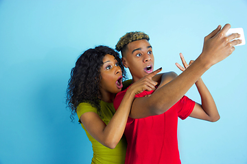 Image showing Young emotional african-american man and woman on blue background