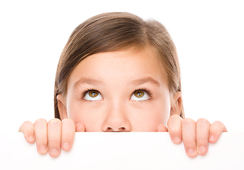 Image showing Little girl is looking from out blank board