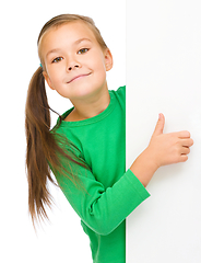 Image showing Little girl is looking from out blank board