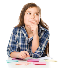 Image showing Girl is writing on color stickers using pen