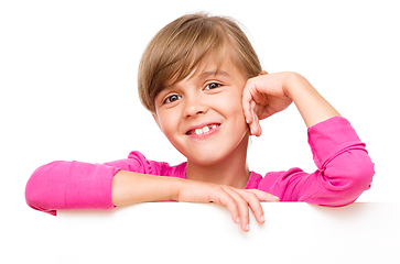 Image showing Little girl is looking out from the blank banner