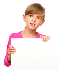 Image showing Little girl is looking out from the blank banner