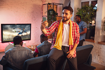 Image showing Group of friends watching TV, sport match together. Emotional man cheering for favourite team, celebrating successful betting. Concept of friendship, leisure activity, emotions