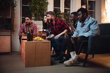 Image showing Group of friends watching TV, sport match together. Emotional fans cheering for favourite team, watching on exciting game. Concept of friendship, leisure activity, emotions