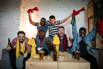 Image showing Group of friends watching TV, sport match together. Emotional fans cheering for favourite team, watching on exciting game. Concept of friendship, leisure activity, emotions