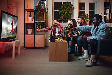 Image showing Group of friends watching TV, sport match together. Emotional fans cheering for favourite team, watching on exciting game. Concept of friendship, leisure activity, emotions