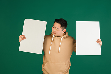 Image showing Asian man\'s portrait isolated over green studio background with copyspace