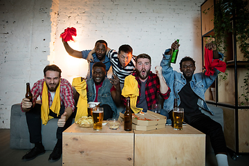 Image showing Group of friends watching TV, sport match together. Emotional fans cheering for favourite team, watching on exciting game. Concept of friendship, leisure activity, emotions