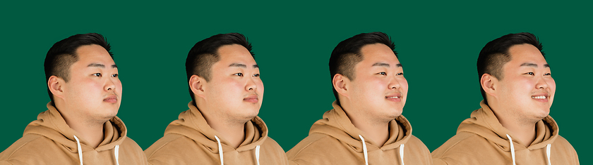 Image showing Evolution of emotions. Asian man\'s portrait isolated over green studio background with copyspace