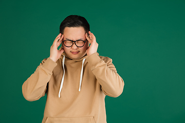 Image showing Asian man\'s portrait isolated over green studio background with copyspace