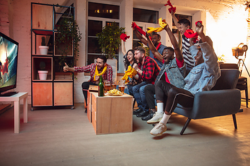 Image showing Group of friends watching TV, sport match together. Emotional fans cheering for favourite team, watching on exciting game. Concept of friendship, leisure activity, emotions