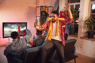 Image showing Group of friends watching TV, sport match together. Emotional man cheering for favourite team, celebrating successful betting. Concept of friendship, leisure activity, emotions