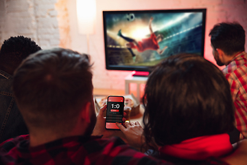 Image showing Group of friends watching TV, sport match together. Emotional fans cheering for favourite team, watching on exciting game. Concept of friendship, leisure activity, emotions