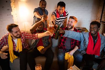 Image showing Group of friends watching TV, sport match together. Emotional fans cheering for favourite team, watching on exciting game. Concept of friendship, leisure activity, emotions