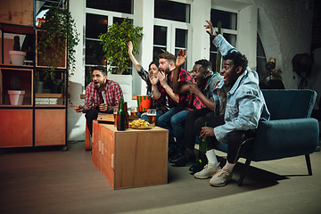 Image showing Group of friends watching TV, sport match together. Emotional fans cheering for favourite team, watching on exciting game. Concept of friendship, leisure activity, emotions
