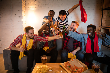 Image showing Group of friends watching TV, sport match together. Emotional fans cheering for favourite team, watching on exciting game. Concept of friendship, leisure activity, emotions