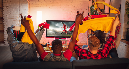 Image showing Group of friends watching TV, sport match together. Emotional fans cheering for favourite team, watching on exciting game. Concept of friendship, leisure activity, emotions