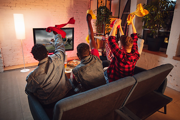 Image showing Group of friends watching TV, sport match together. Emotional fans cheering for favourite team, watching on exciting game. Concept of friendship, leisure activity, emotions